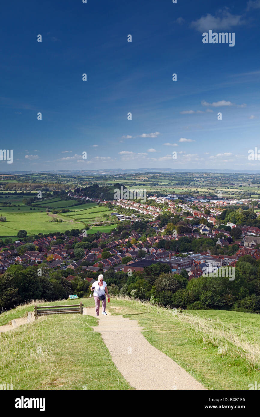 Eine einsame weibliche Wanderer auf dem Weg zum Gipfel des Glastonbury Tor mit Blick auf den Somerset Levels, England, UK Stockfoto