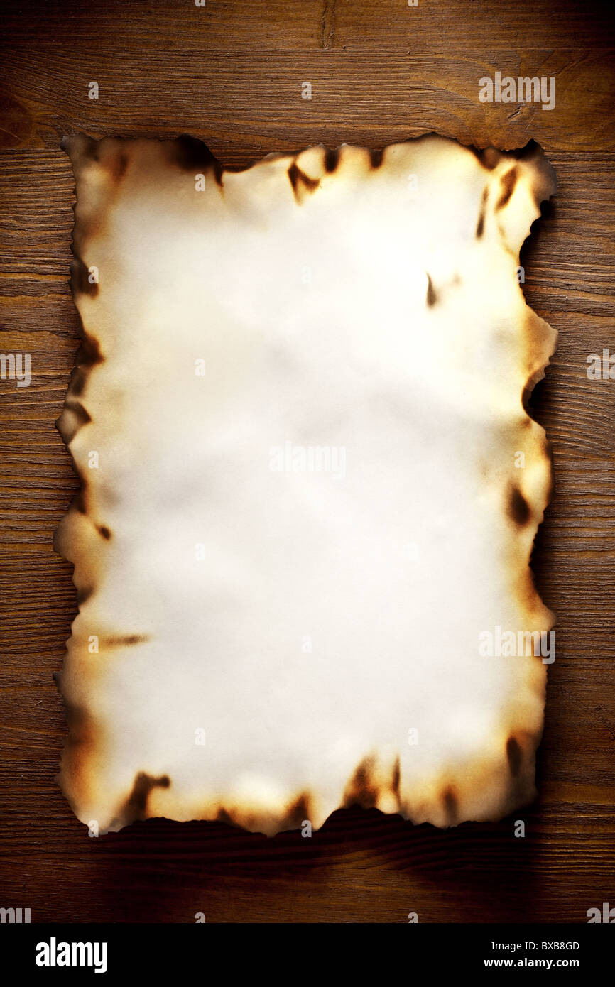 Auf den Kanten texturierte Papier gegen eine Holzwand verbrannt Stockfoto