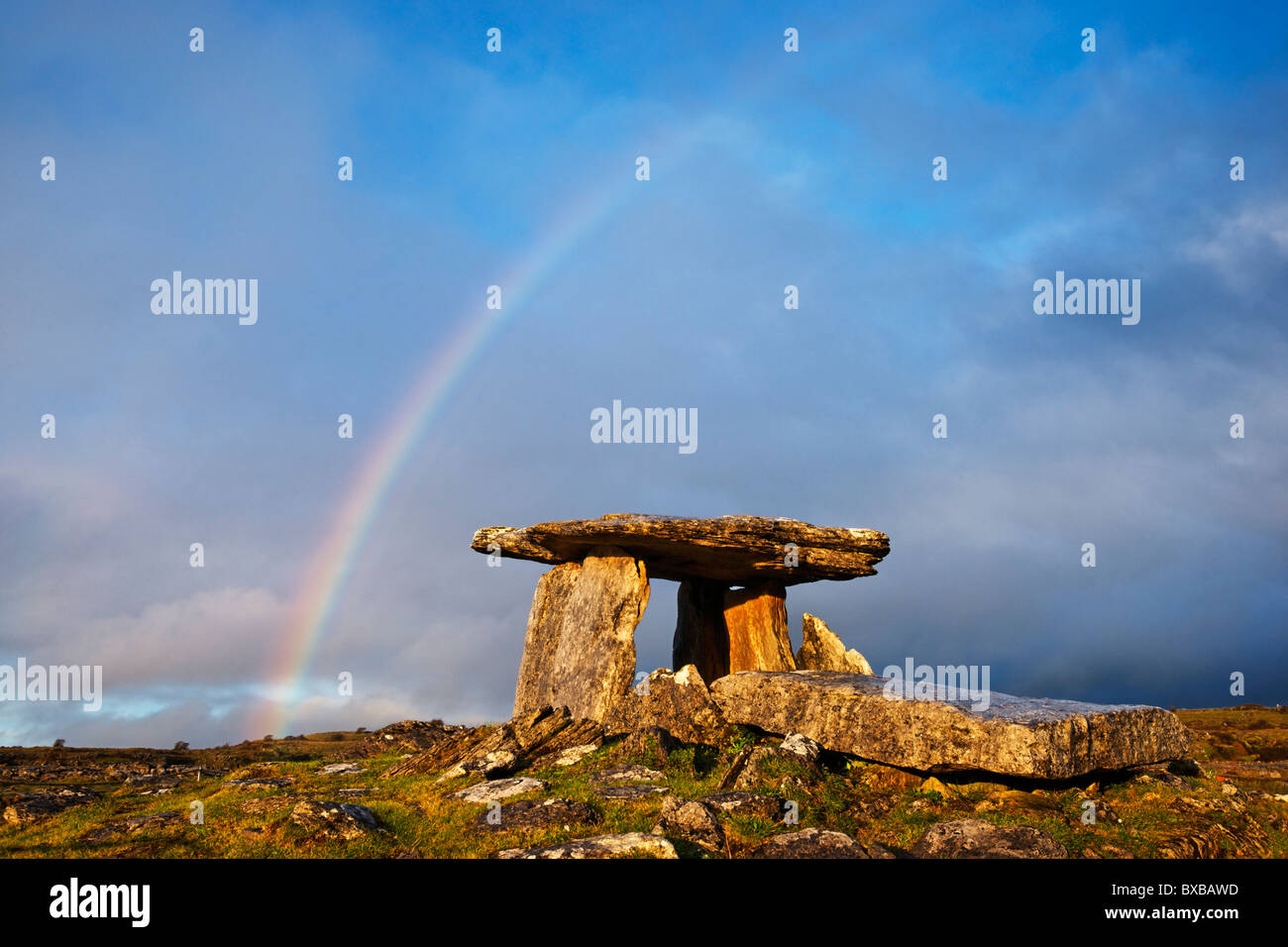Poulnabrone Dolmen (Umfrage Na mBron) und Regenbogen, Burren, County Clare, Munster, Irland. Stockfoto