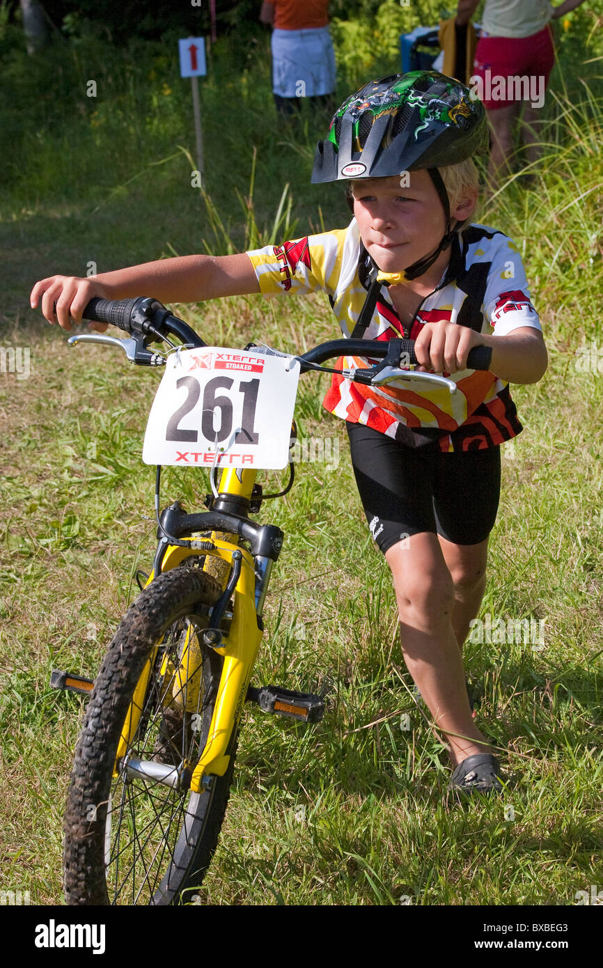 Kleiner Junge schiebt Mountainbike bergauf in eine Jugend Straße Triathlon  Rennen Wettbewerb Stockfotografie - Alamy