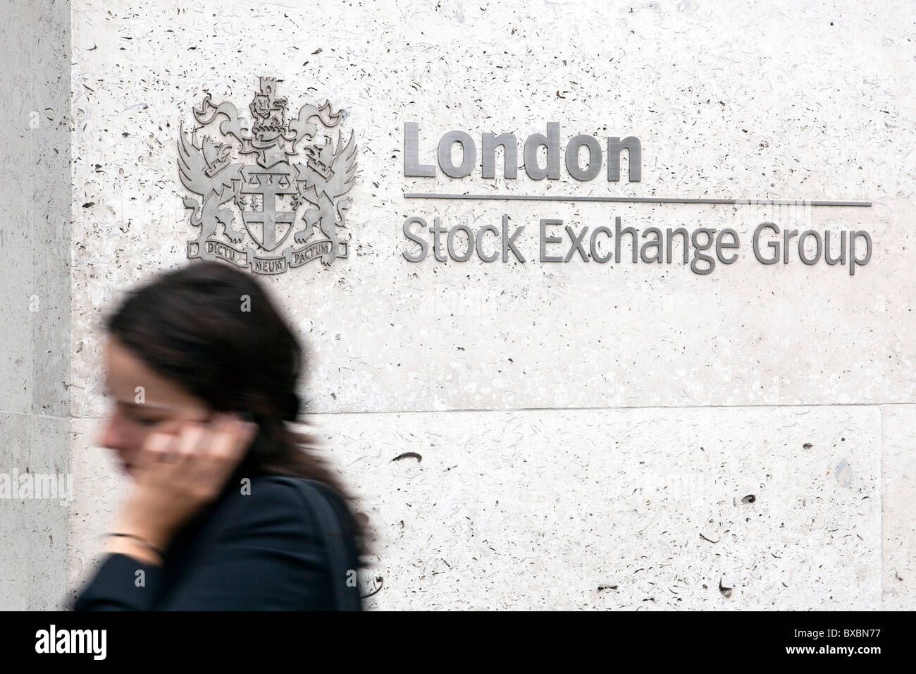 Frau vor dem Logo der London Stock Exchange Group, in London, England, Vereinigtes Königreich, Europa Stockfoto