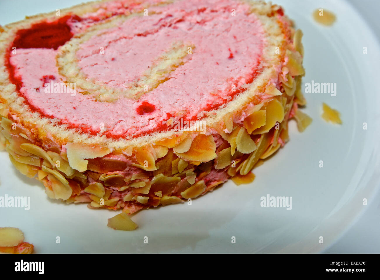 Erdbeer Eis Kuchen Roll bedeckt in gerösteten Mandelsplitter dessert Stockfoto