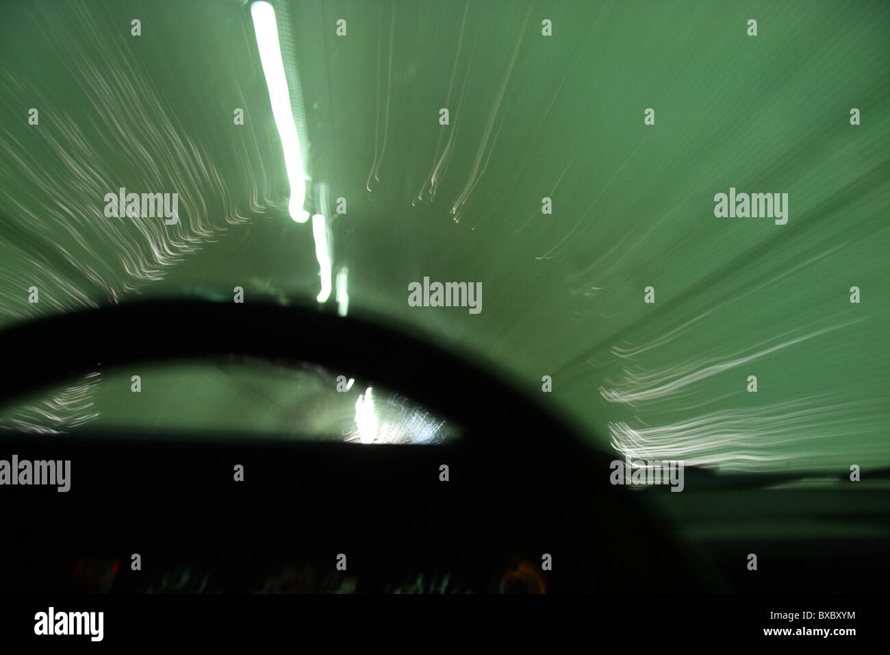 Bewegungsunschärfe des Autos durch einen Tunnel mit Lenkrad im Vordergrund Stockfoto