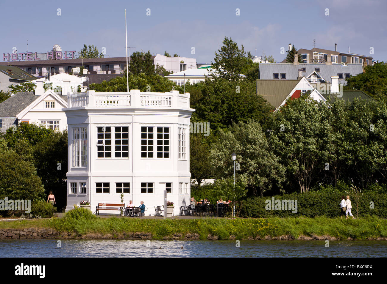Menschen sitzen vor einem Café Tjörnin See. Reykjavik Island Stockfoto