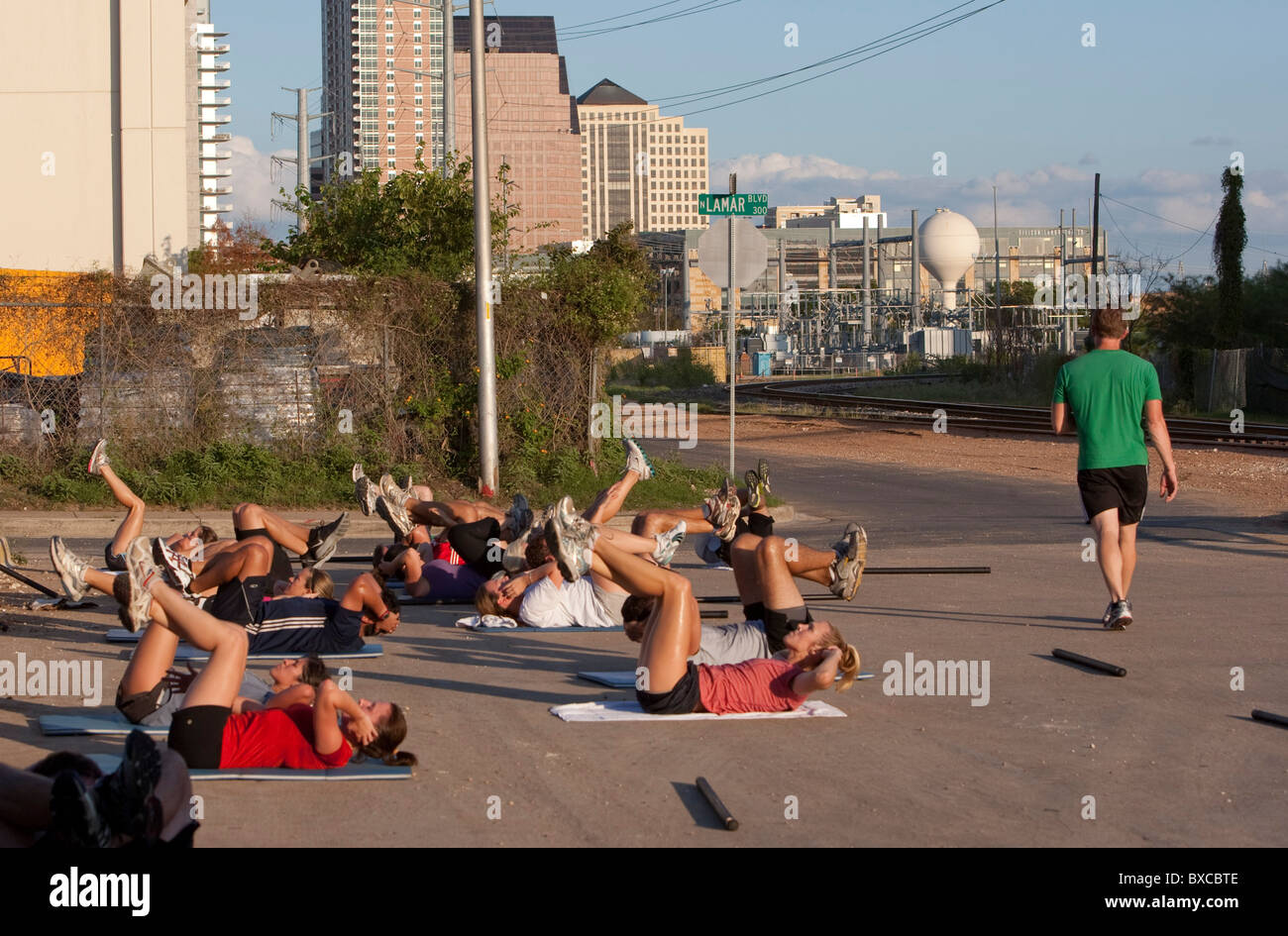 Männer und Frauen tun Bauch-Crunches während der Übung in der Innenstadt von Austin, Texas Stockfoto