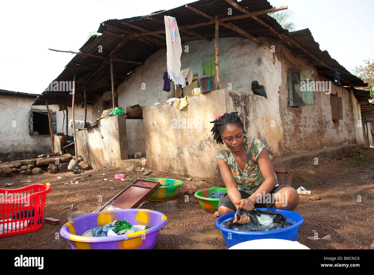 Eine Frau wäscht Kleidung in einer Wohngegend in Freetown, Sierra Leone, Westafrika. Stockfoto