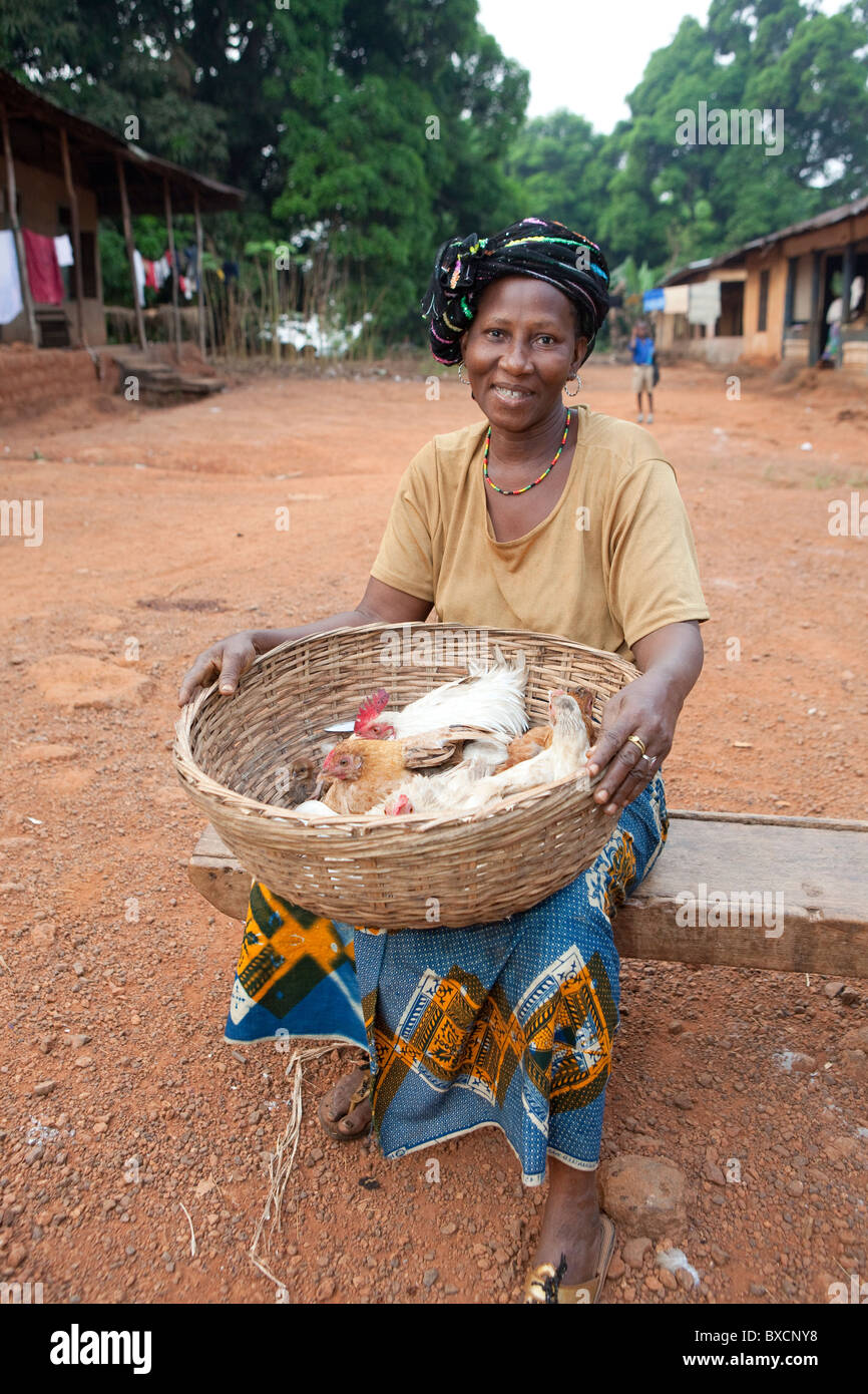 Eine Frau sitzt auf dem Markt mit einem Korb voller Hühner in Port Loko, Sierra Leone, Westafrika. Stockfoto