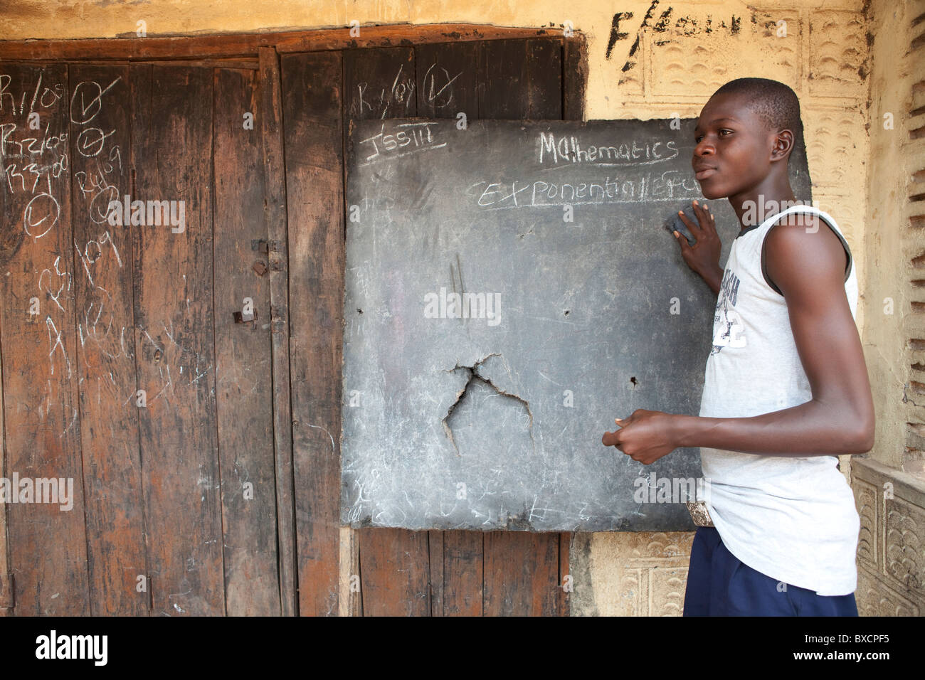 Ein junger Mann schreibt auf eine Schultafel in Masiaka, Sierra Leone, Westafrika. Stockfoto