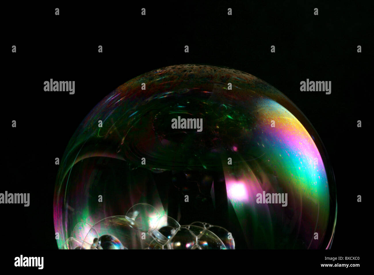 Eine Nahaufnahme von einer Seifenblase widerspiegelt einen Regenbogen von Licht auf einem schwarzen Hintergrund. Stockfoto