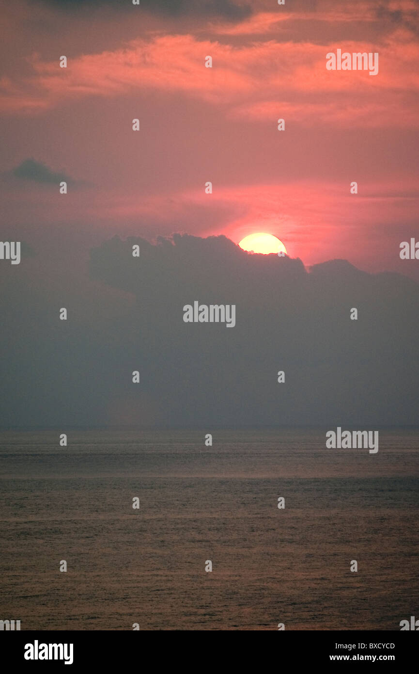 Roten Sonnenuntergang über dem Ozean hinter den Wolken versteckt Stockfoto