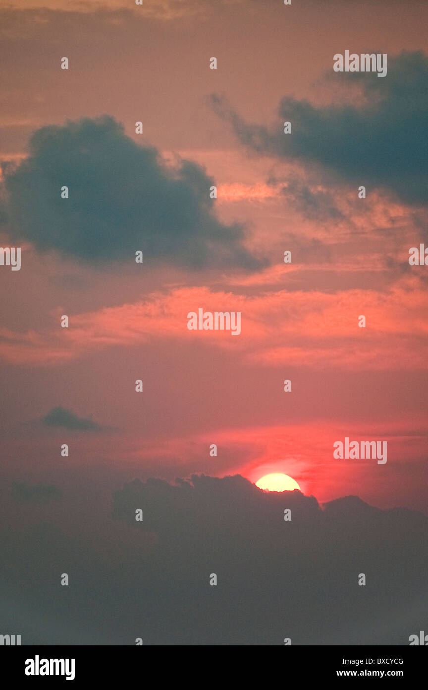 Roten Sonnenuntergang über dem Ozean hinter den Wolken versteckt Stockfoto