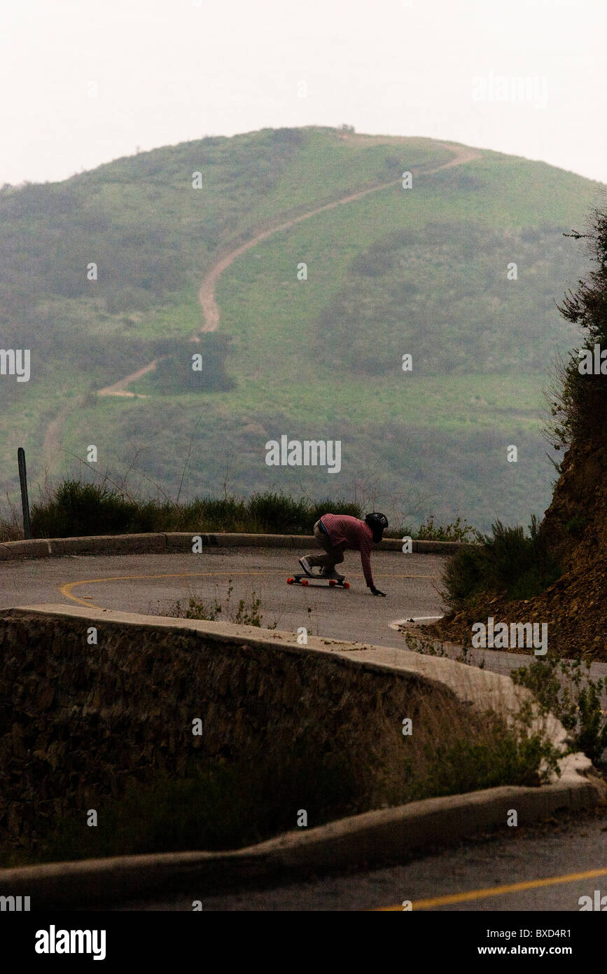 Ein downhill Skateboarder fährt einen steilen Berg hinunter. Stockfoto