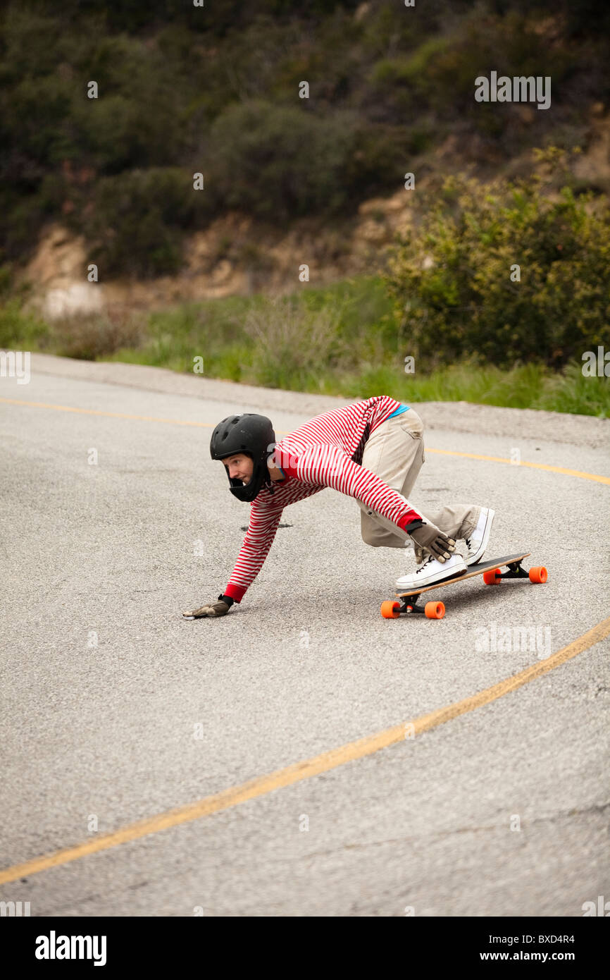 Ein downhill Skateboarder fährt einen steilen Berg hinunter. Stockfoto