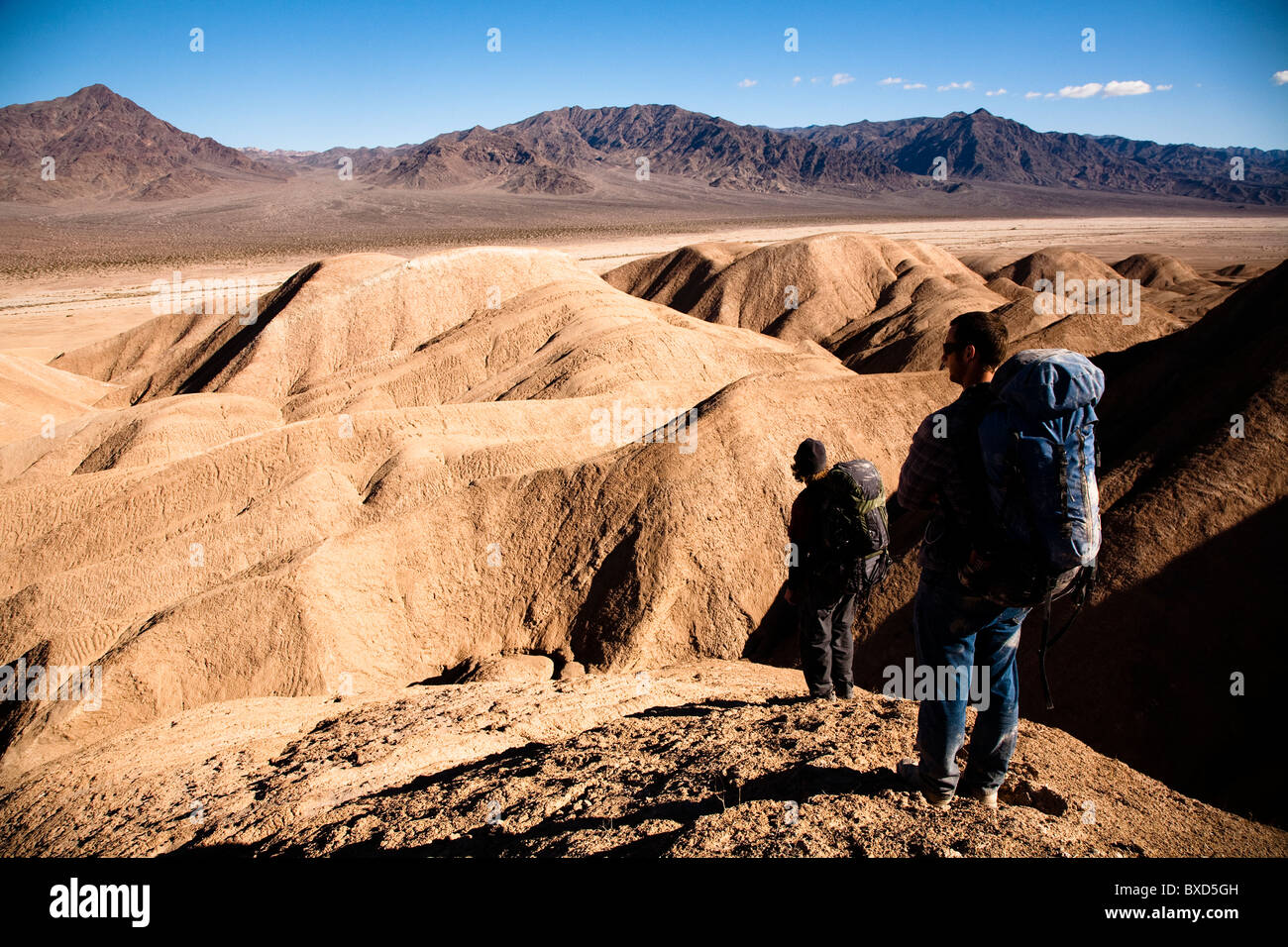 Zwei männliche Wanderer suchen, um die beste Route durch Death Valley Vertrauen Hills in Kalifornien, zu finden, während auf der Verpackung sichern. Stockfoto
