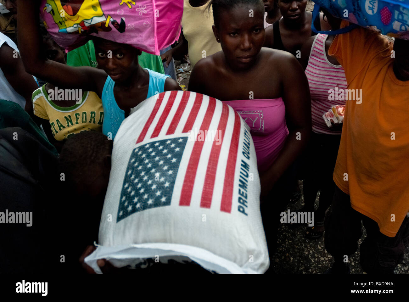 Eine haitianische Frau trägt einen Beutel mit den US-Reis auf dem Markt von La Saline, Port-au-Prince, Haiti. Stockfoto