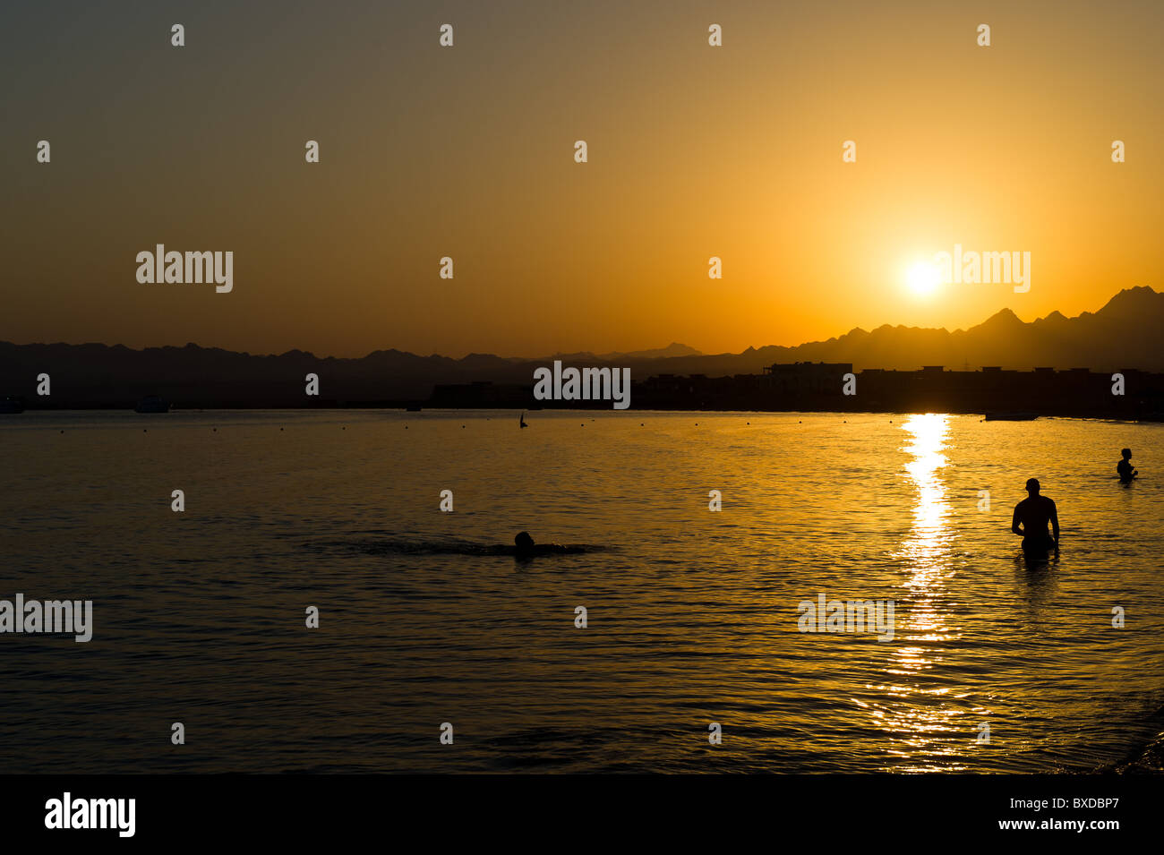 Menschen schwimmen im Roten Meer bei Sonnenuntergang in der Soma Bay in der Nähe von Safaga und Hurghada in Ägypten Stockfoto