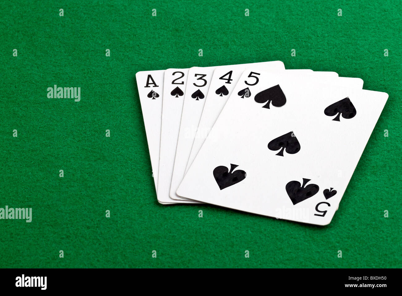 Poker-Blatt mit einem Ostwind-Flush Pik auf grünem Filz Stockfoto