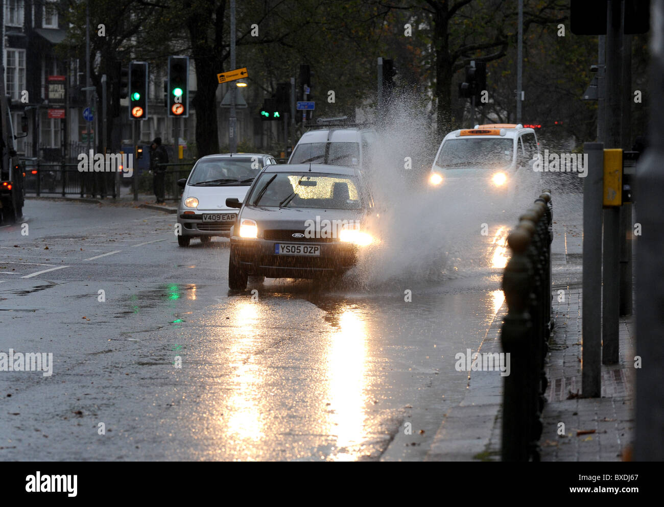 Autos fahren durch tiefe Pfützen auf Brighton Lewes Straße nach Sintflut von heavy rain Stockfoto