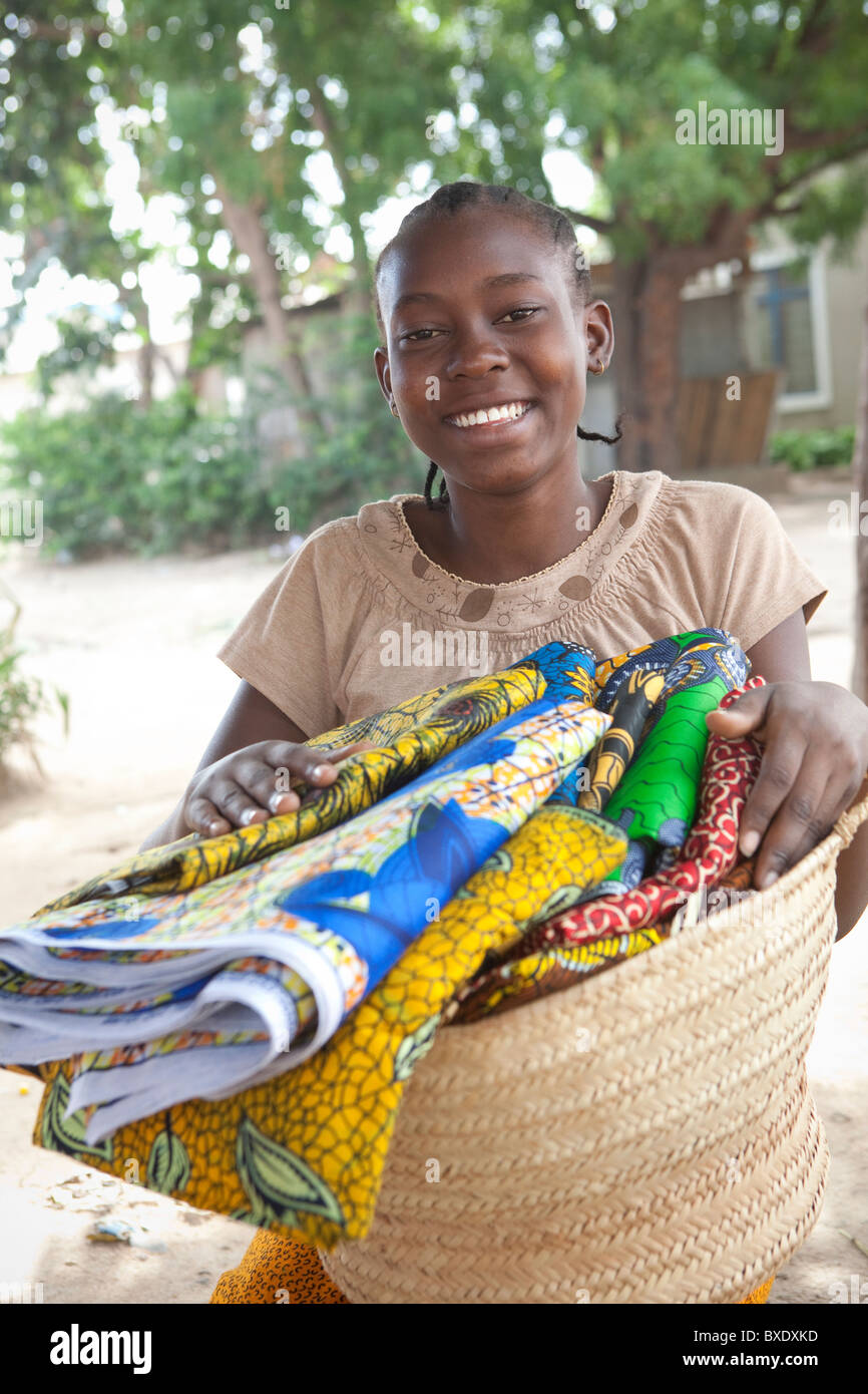 Eine junge Frau verkauft Stoffe und Textilien Tür zu Tür in Dodoma, Tansania, Ostafrika. Stockfoto