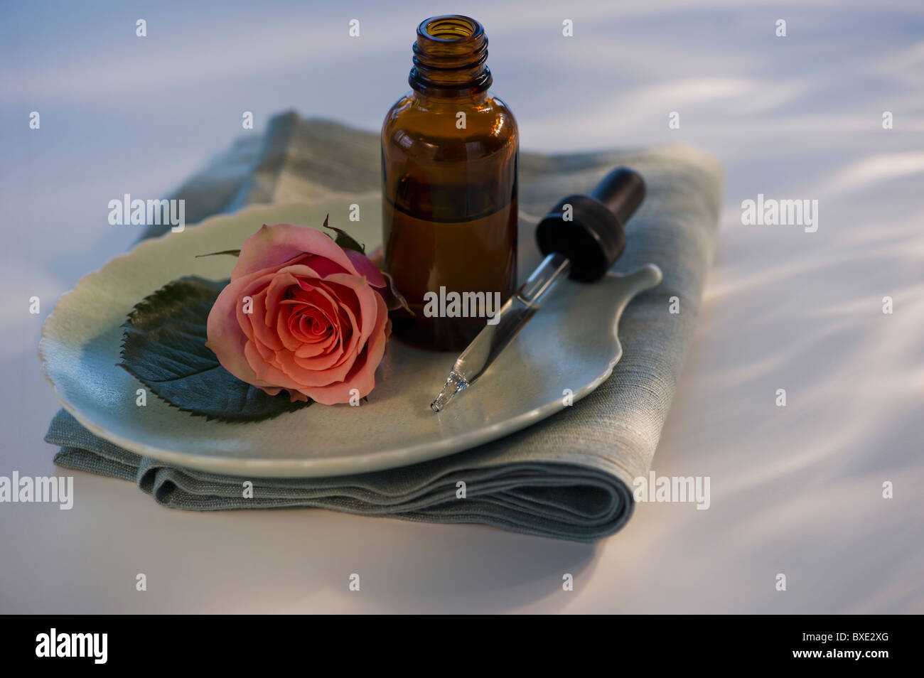 Ätherisches Öl und Rose auf Tablett Stockfoto