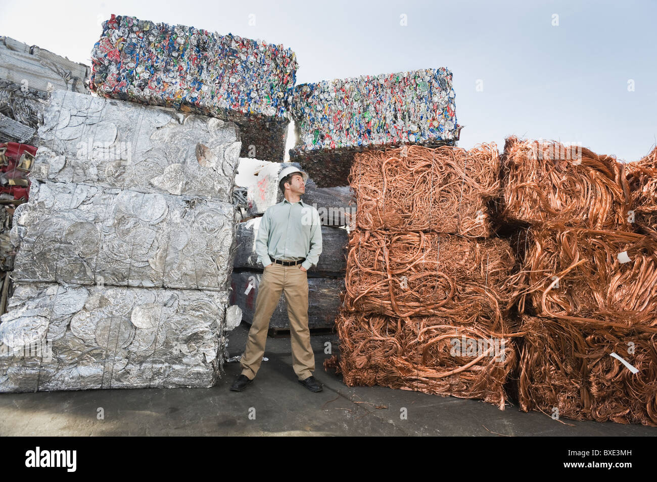 Arbeitnehmer, die neben Stapel von Recycling-material Stockfoto