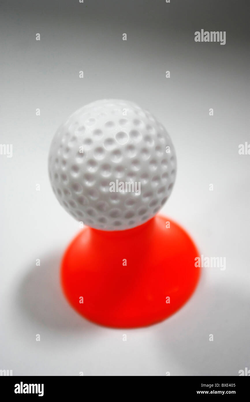 Ein weiße Golfball auf einen roten Stift vor einem weißen Hintergrund platziert Stockfoto