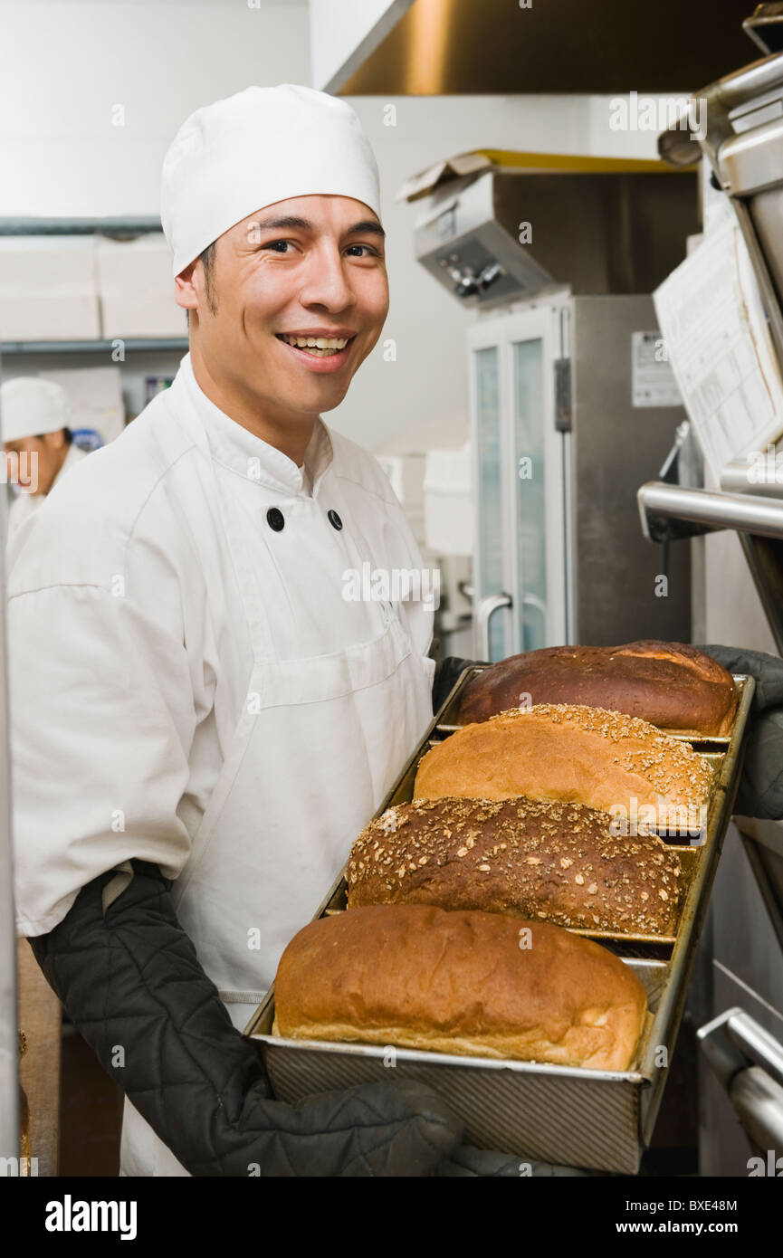 Koch mit Tablett mit frisch gebackenem Brot Stockfoto