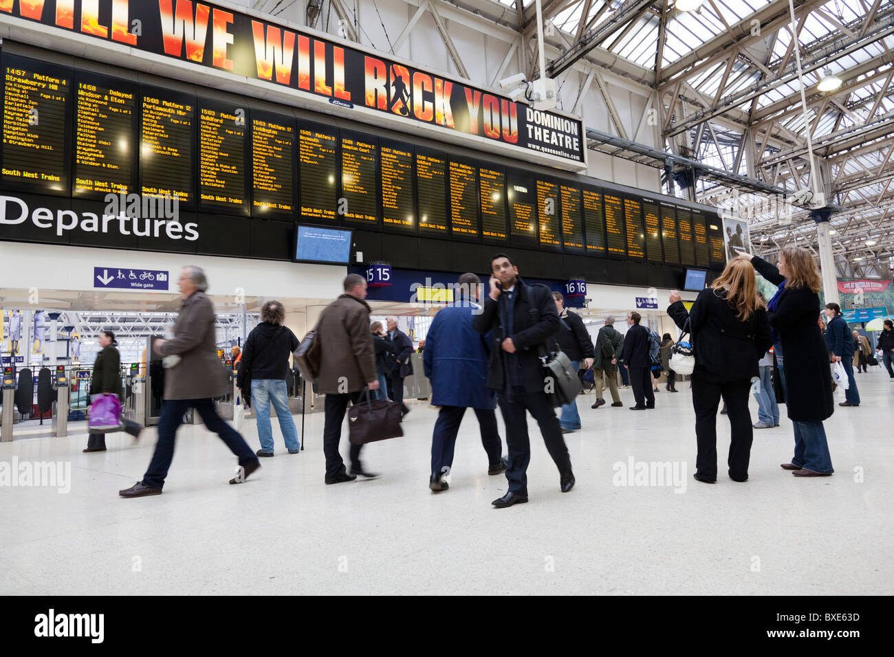 Pendler und Reisende auf das Zusammentreffen der Waterloo Station zeigt den Zeitplan über ihnen. Stockfoto