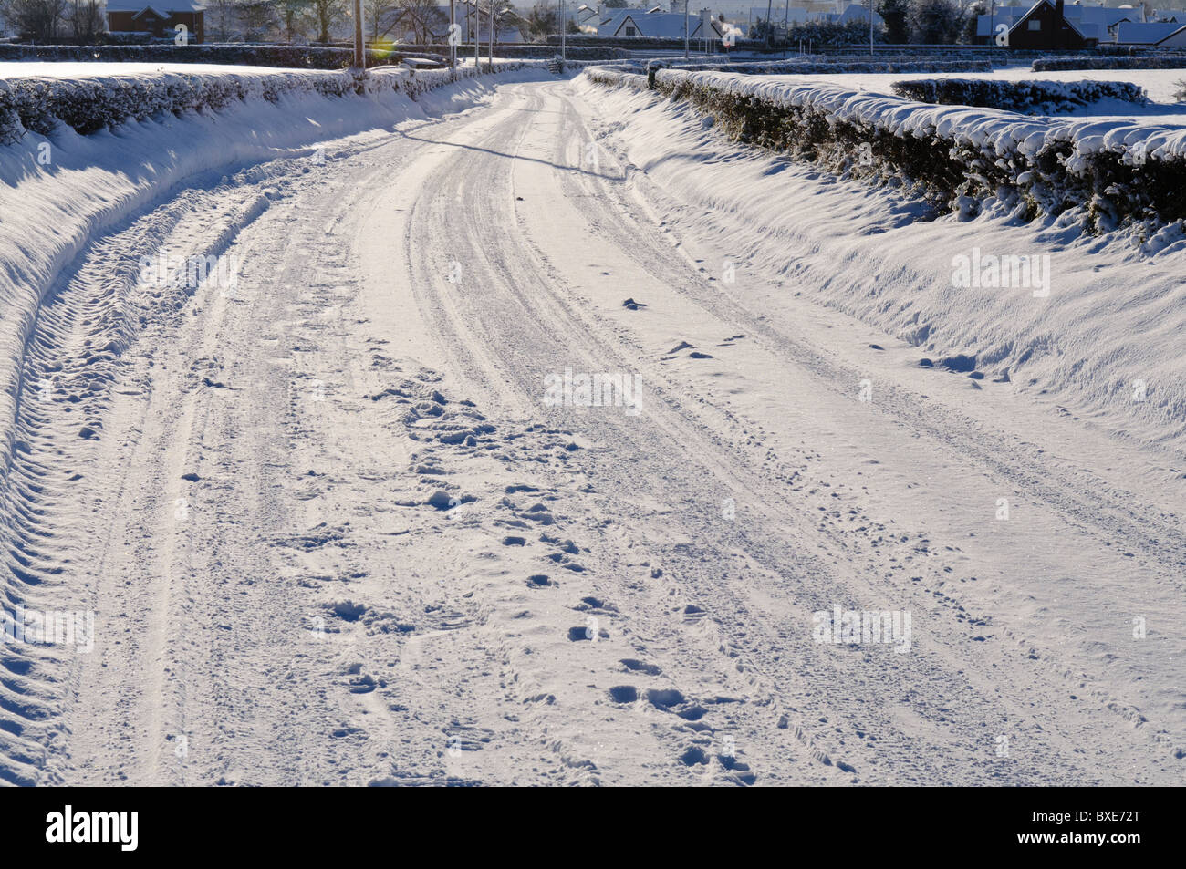 Verschneite Landstraße mit einer Reihe von Reifenspuren Stockfoto