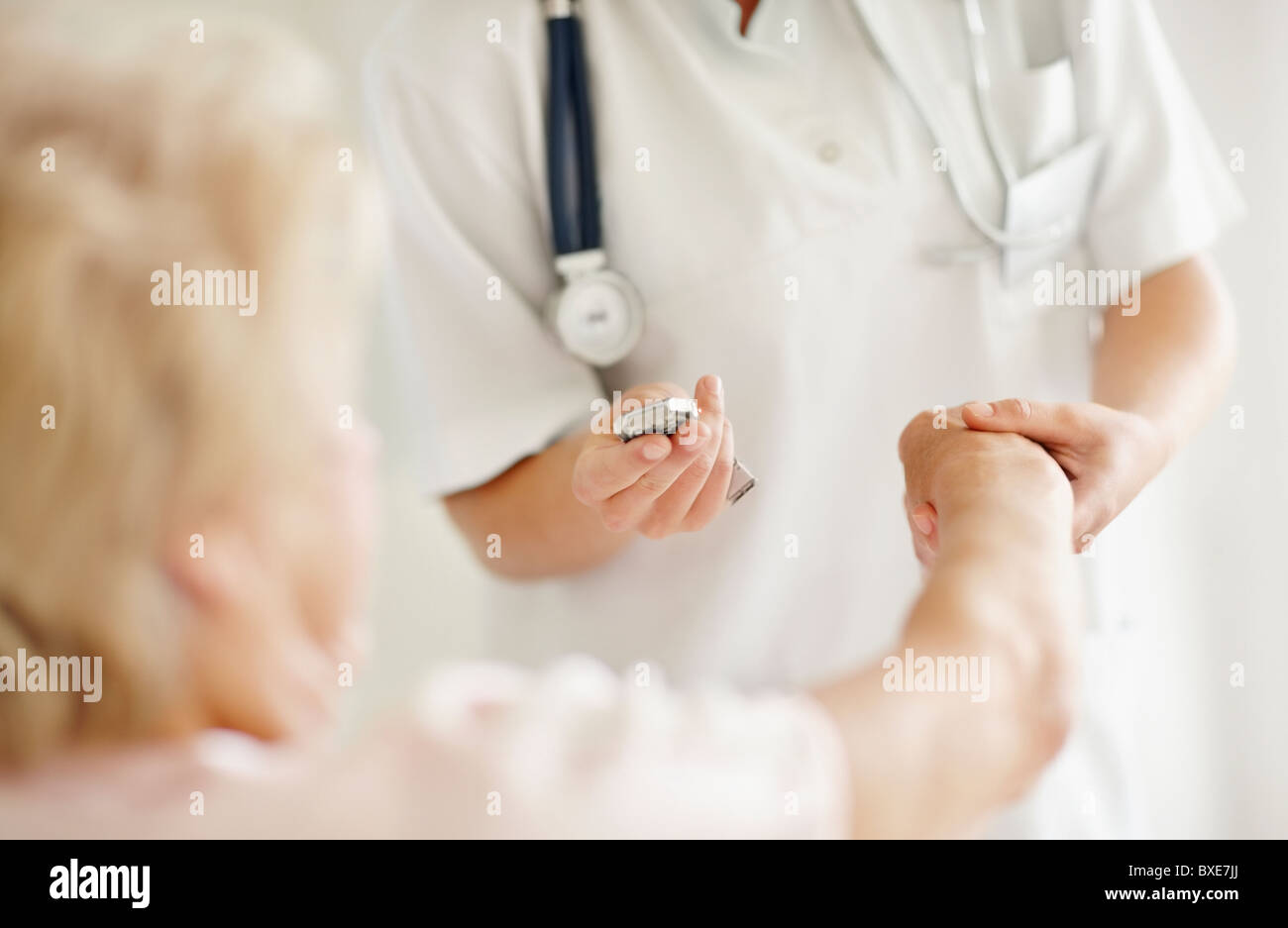 Krankenschwester Einnahme Puls der älteren Frau Stockfoto