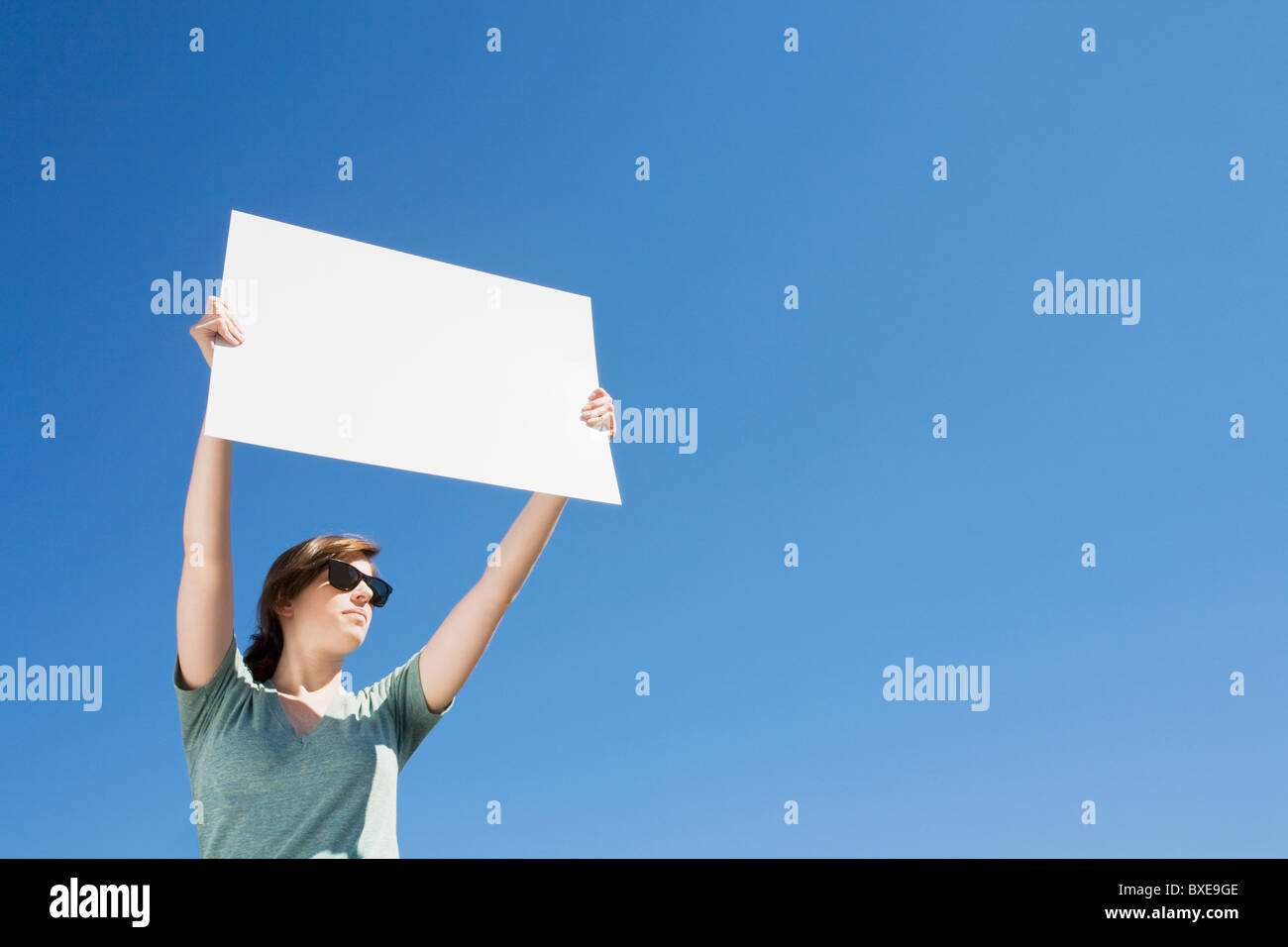 Junge Frau hält ein leeres Plakat Stockfoto