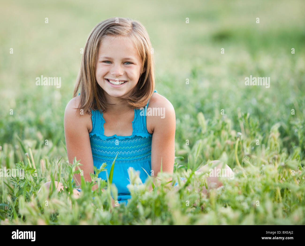 Junges Mädchen sitzen im Feld Stockfoto