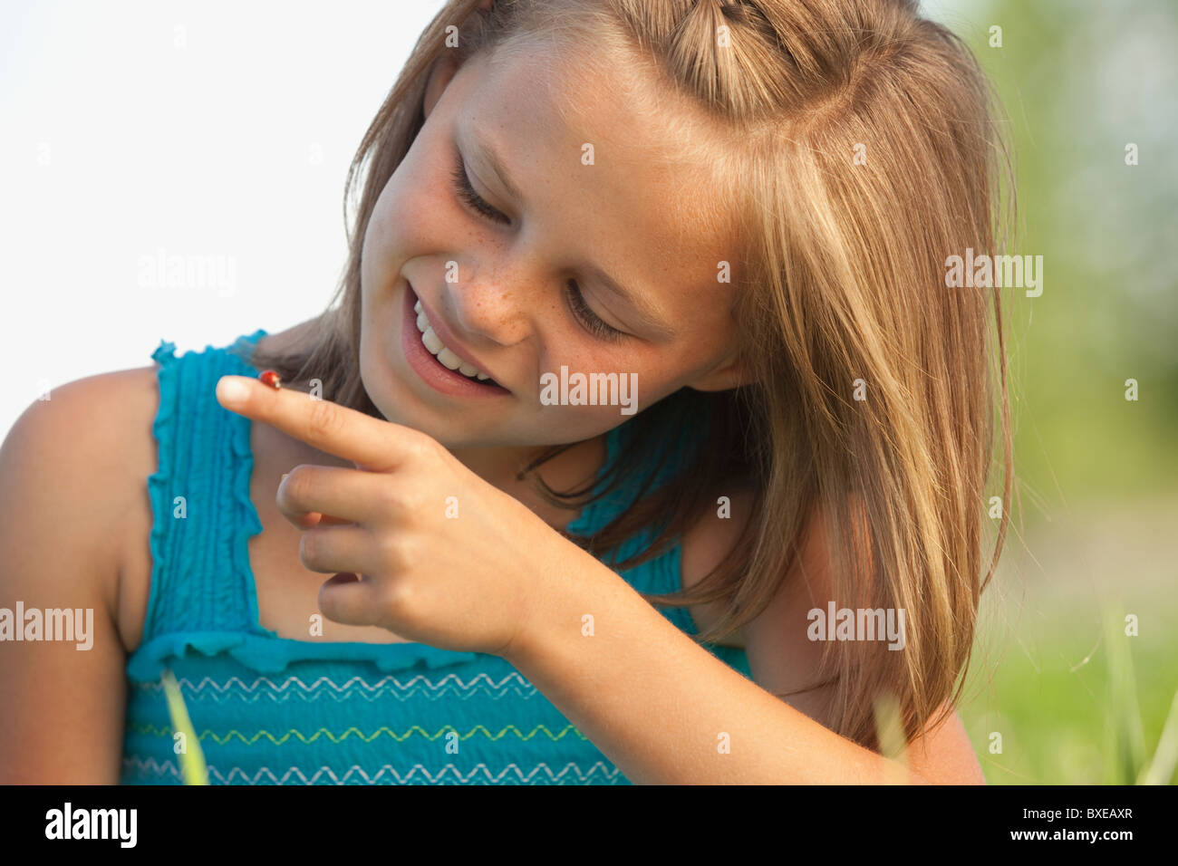 Junges Mädchen Blick auf einen Marienkäfer Stockfoto