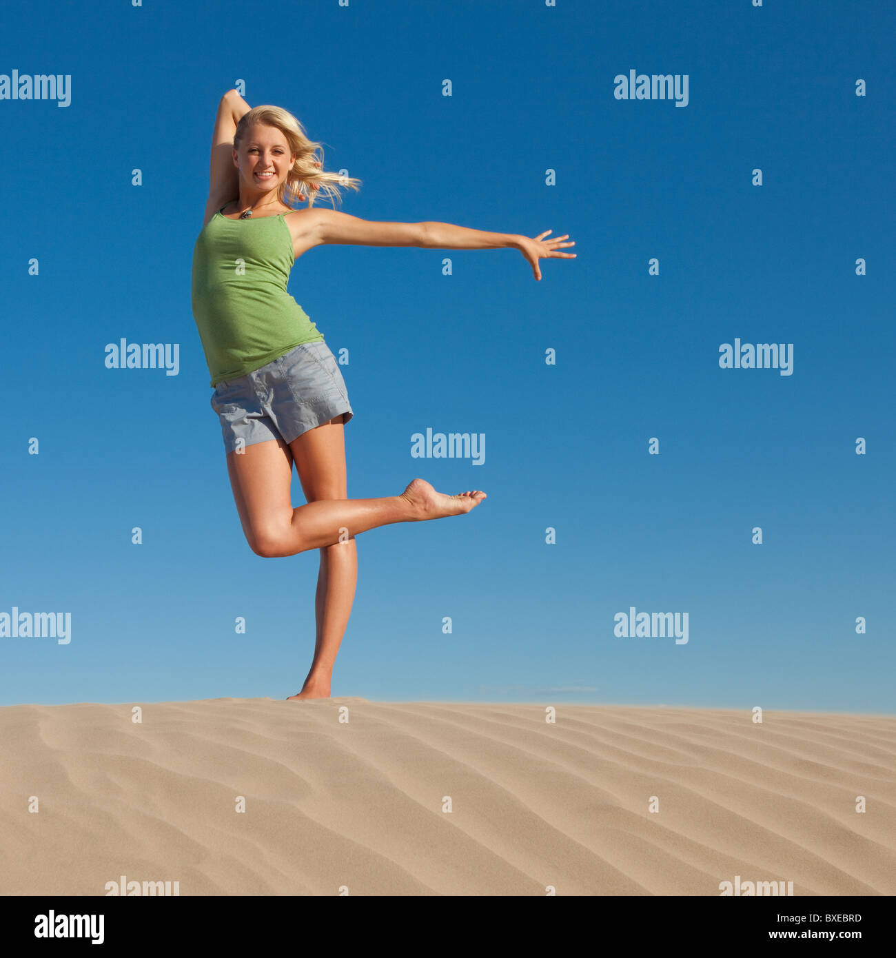 Frau tut Tanz Pose am Strand Stockfoto
