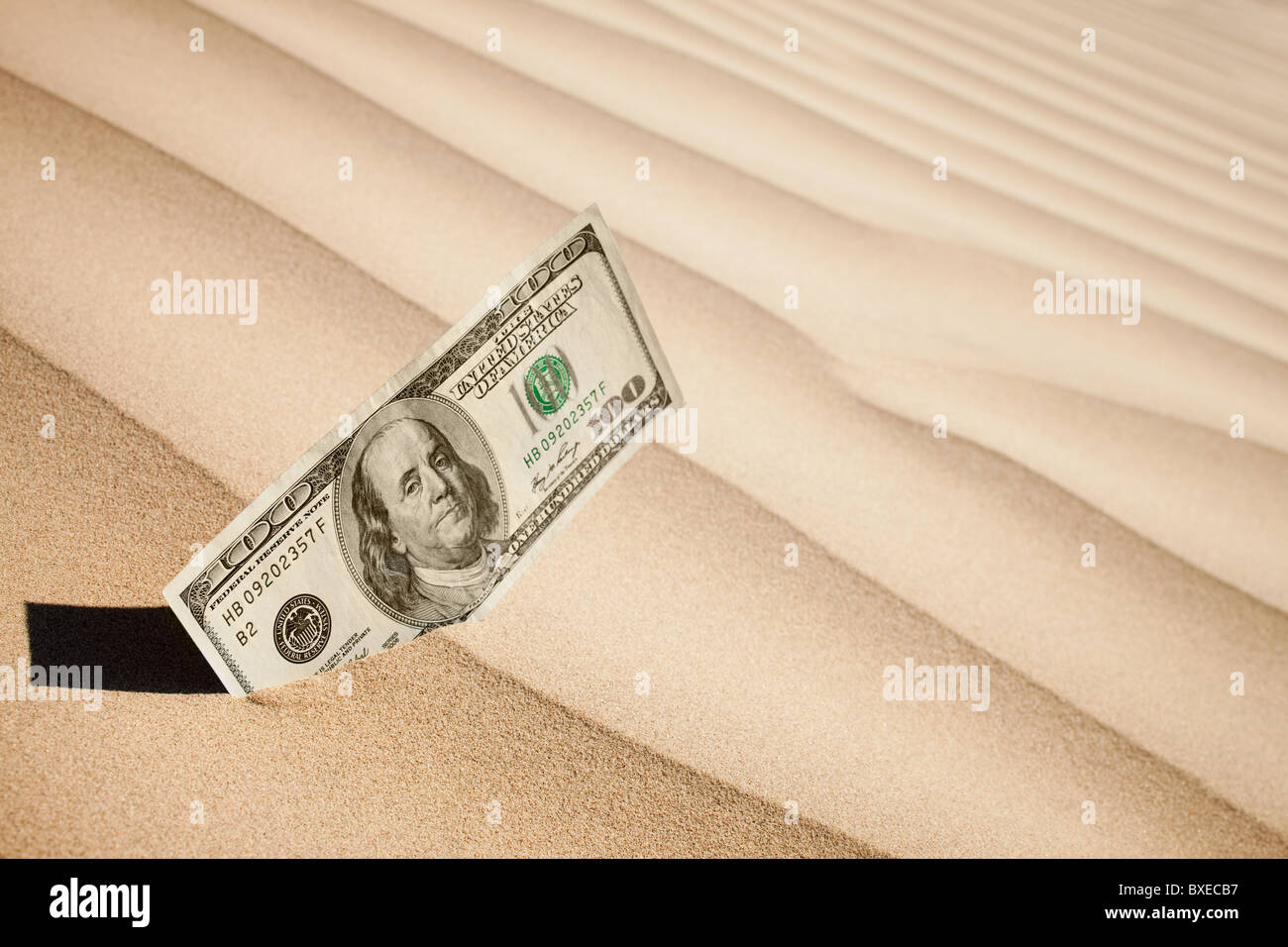 100 Dollarschein in sand Stockfoto