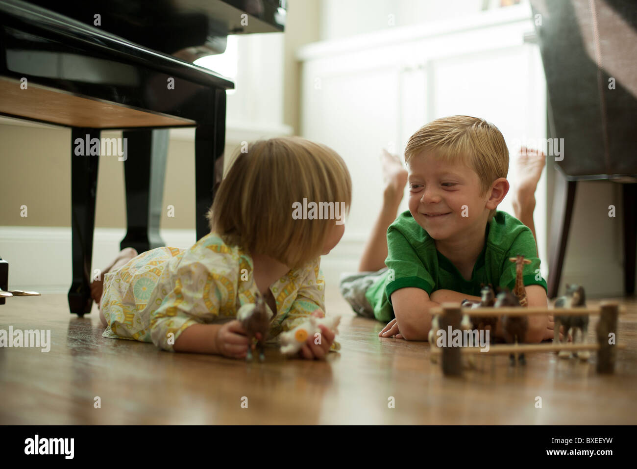 Bruder und Schwester spielt mit Spielzeugtiere Stockfoto