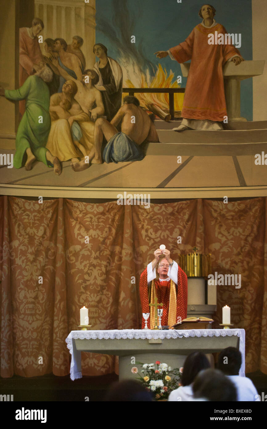 Priester wirft Wafer während der Liturgie der Eucharistie Masse am St.-Laurentius Kirche in Feltham, London. Stockfoto
