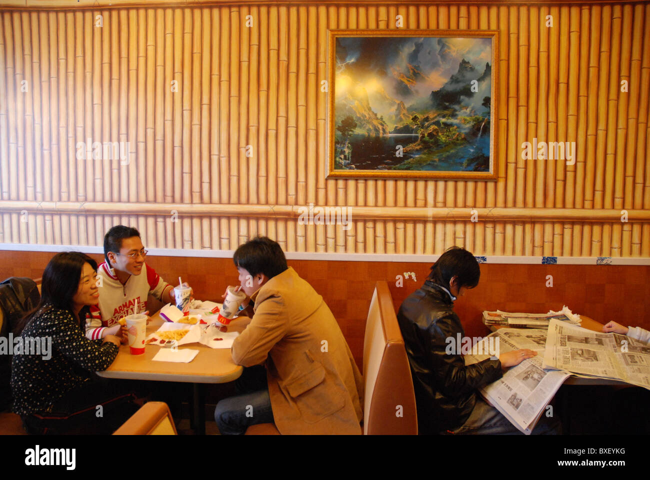Junge Chinesen essen Burger in einem Mc Ferienjob Restaurant in Chinatown Stockfoto