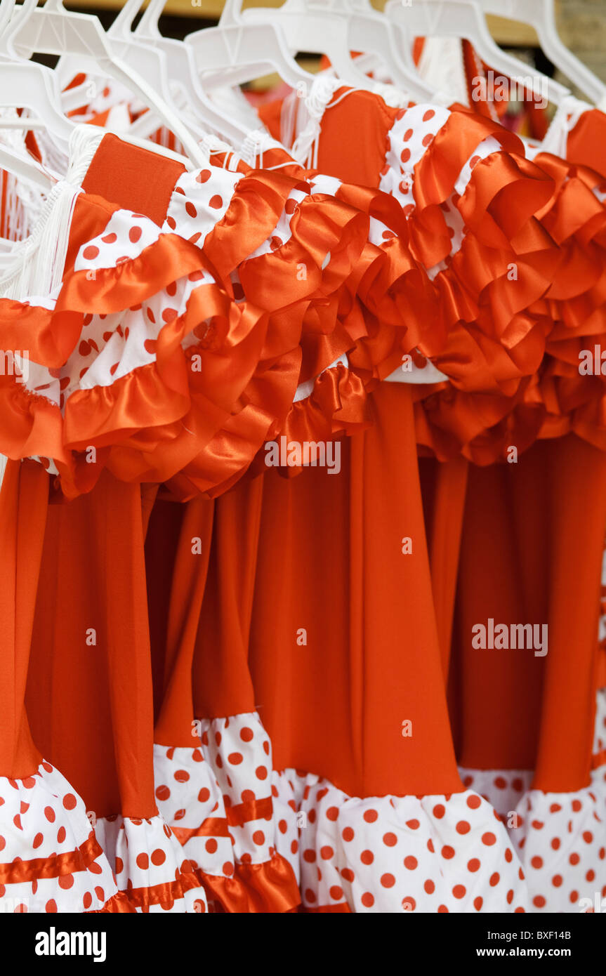 Flamenco-Kleider hängen von einer Schiene in Sevilla, Andalusien, Spanien Stockfoto