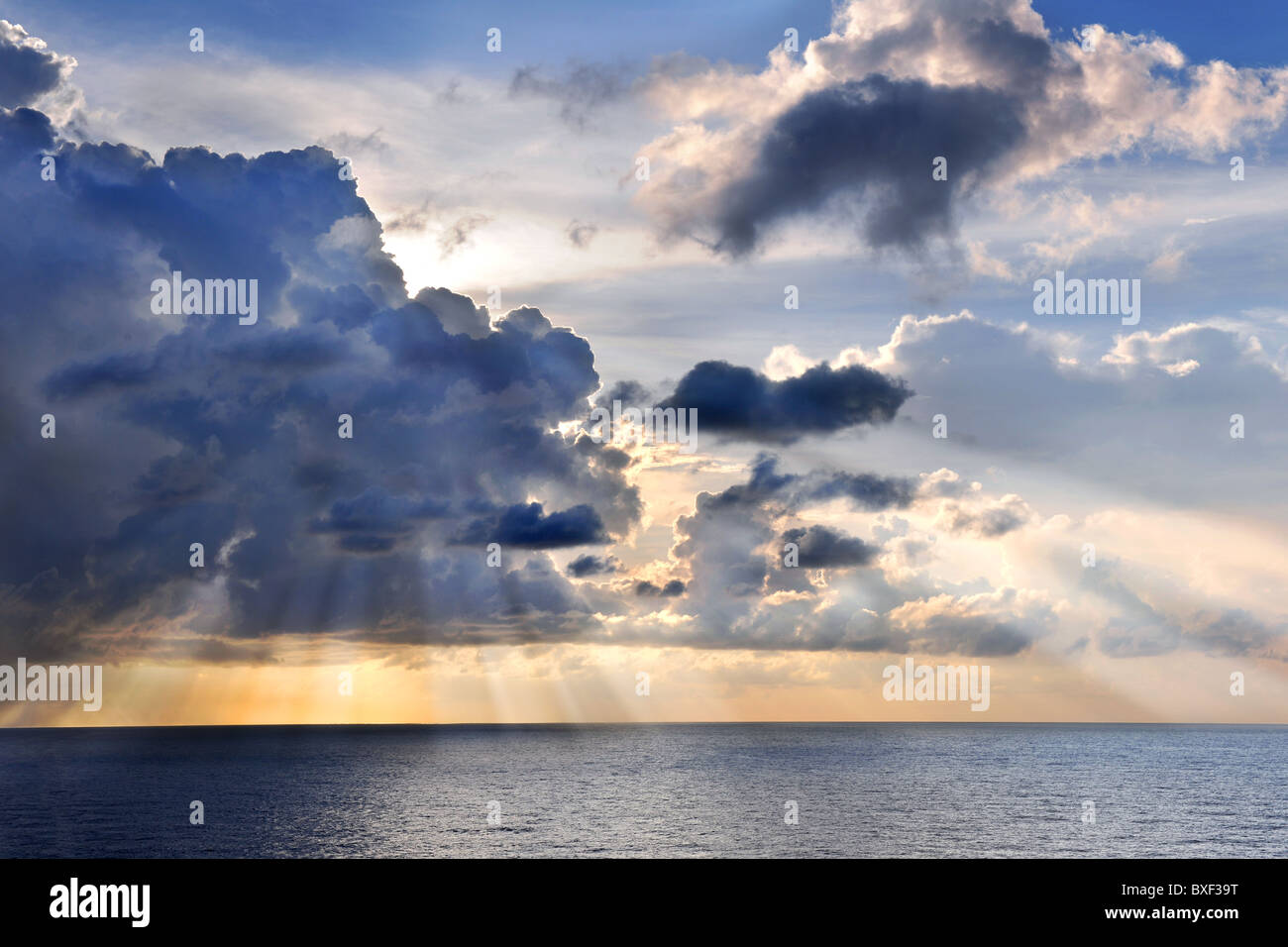 Karibischer Sonnenuntergang am Meer mit Sonne und Wolken Stockfoto