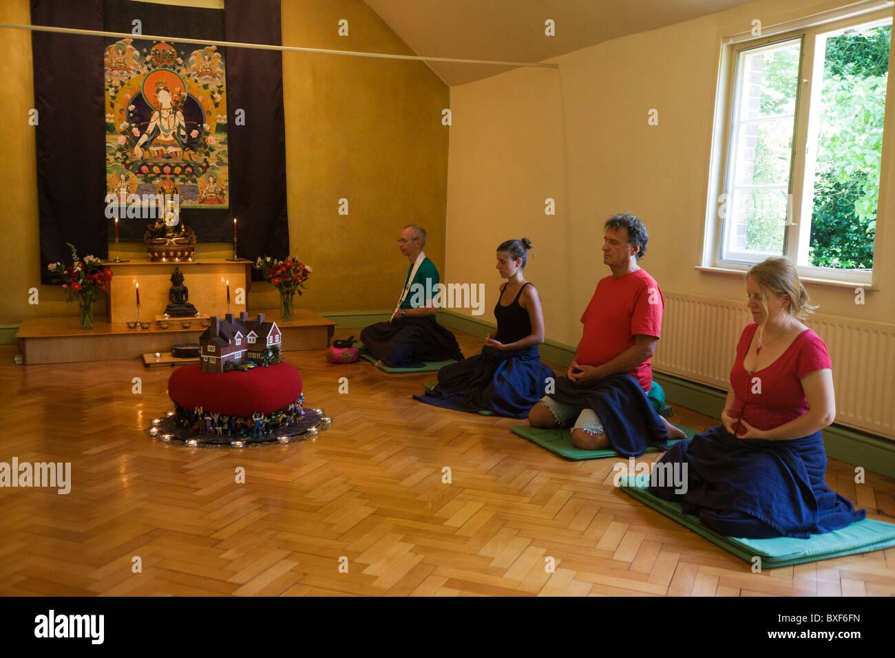 Buddhisten meditieren schweigend für 30 Minuten in den Altarraum in Bruchtal buddhistischen Retreat Centre, England. Stockfoto