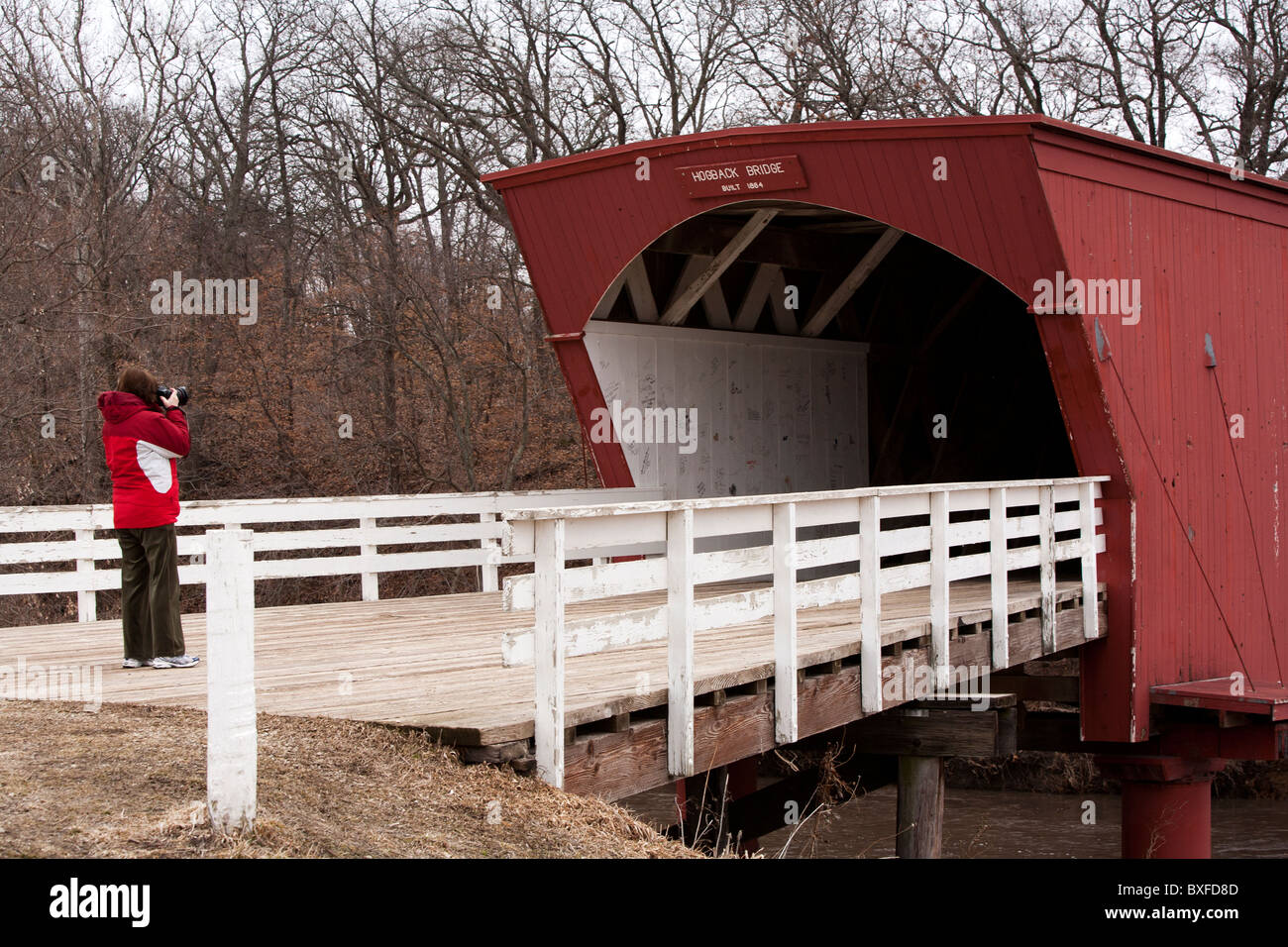 Immer noch ziehen die wenigen restlichen gedeckten Brücken von Madison County, Iowa Touristen. Hier fotografiert ein Tourist der Hogback Brücke Stockfoto