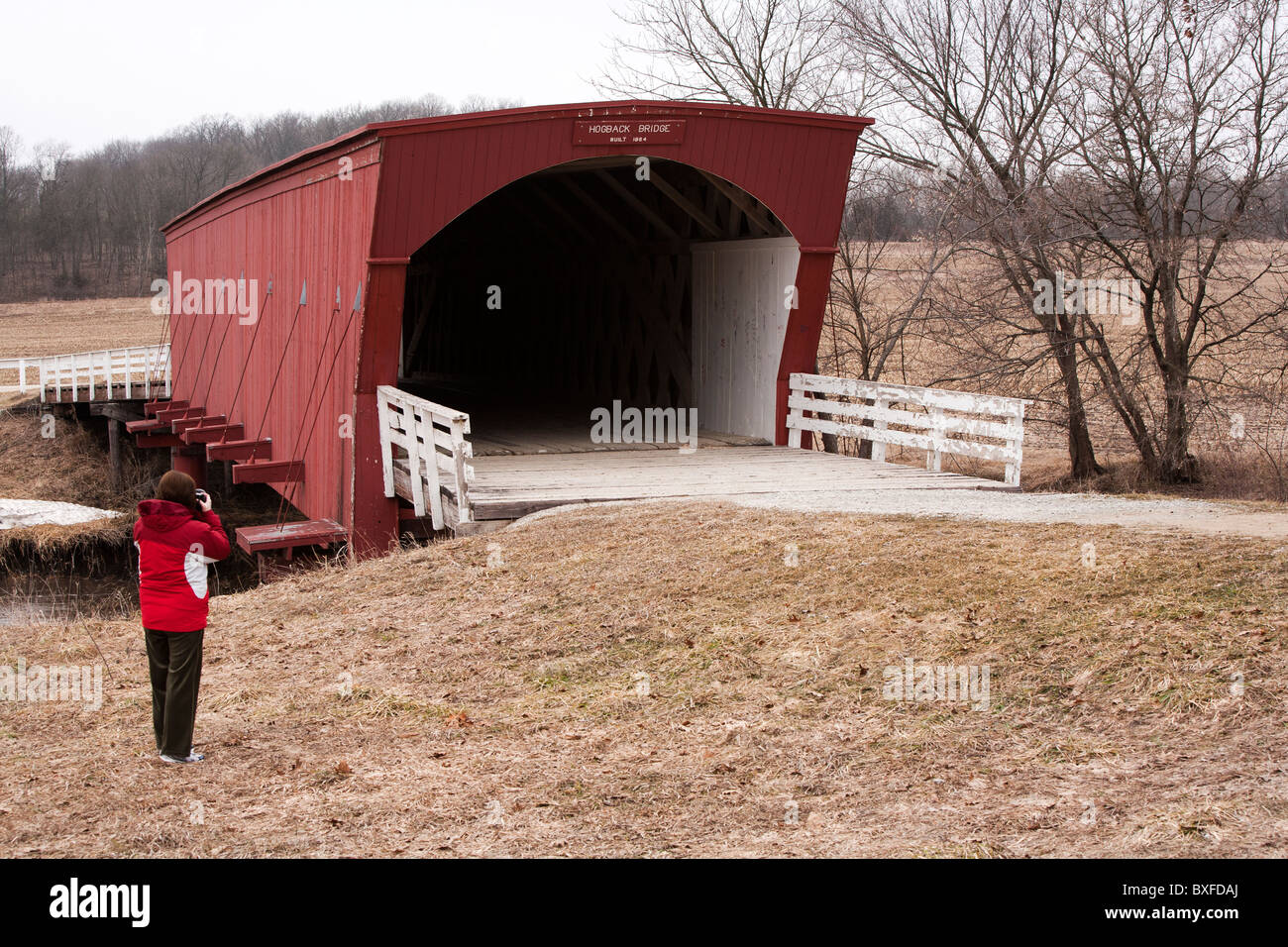 Immer noch ziehen die wenigen restlichen gedeckten Brücken von Madison County, Iowa Touristen. Hier fotografiert ein Tourist der Hogback Brücke Stockfoto