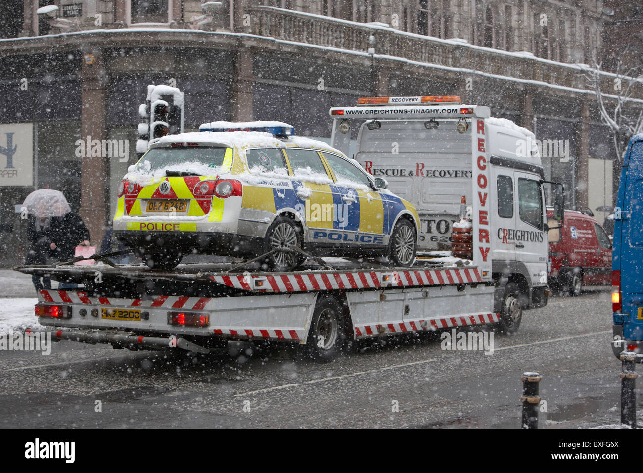 Polizei-Polizei-Fahrzeug für eine Erholung LKW an einem kalten schneereichen Wintertag Belfast Nordirland aufgeschlüsselt Stockfoto