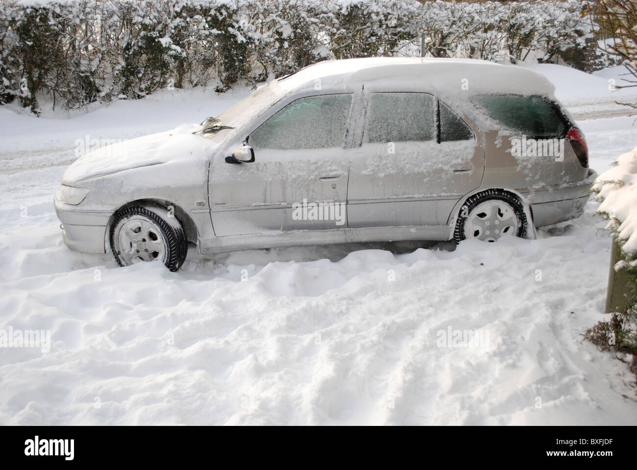 Auto an der Seite einer Schnee und Eis bedeckten Straße aufgegeben. Stockfoto