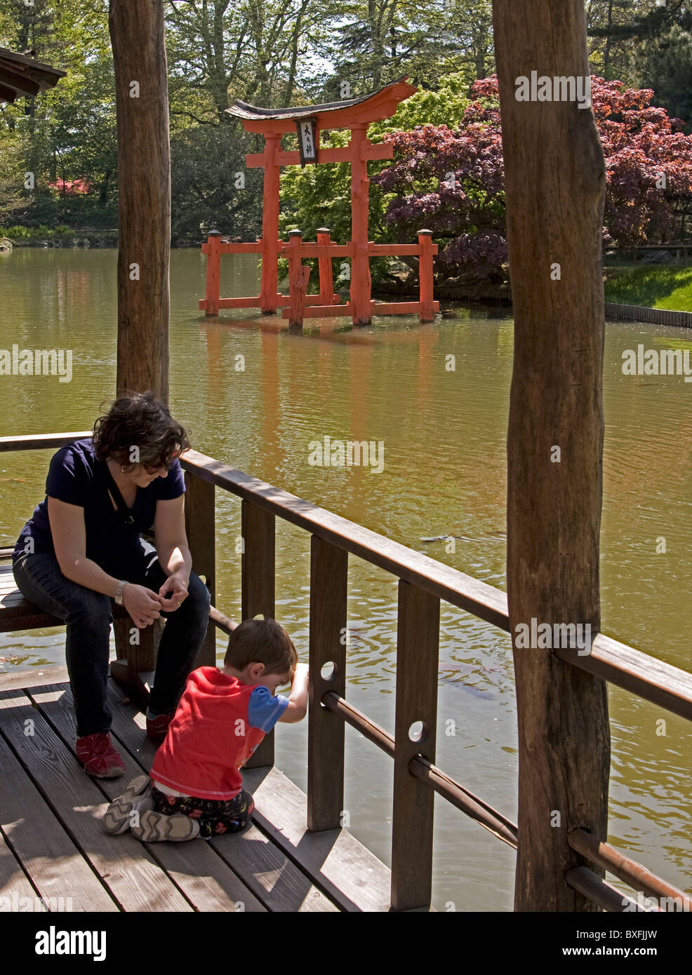 Mutter und Sohn verbringen Sie ruhige Minuten im Brooklyn Botanic Garden mit den japanischen Torii im Hintergrund. Stockfoto