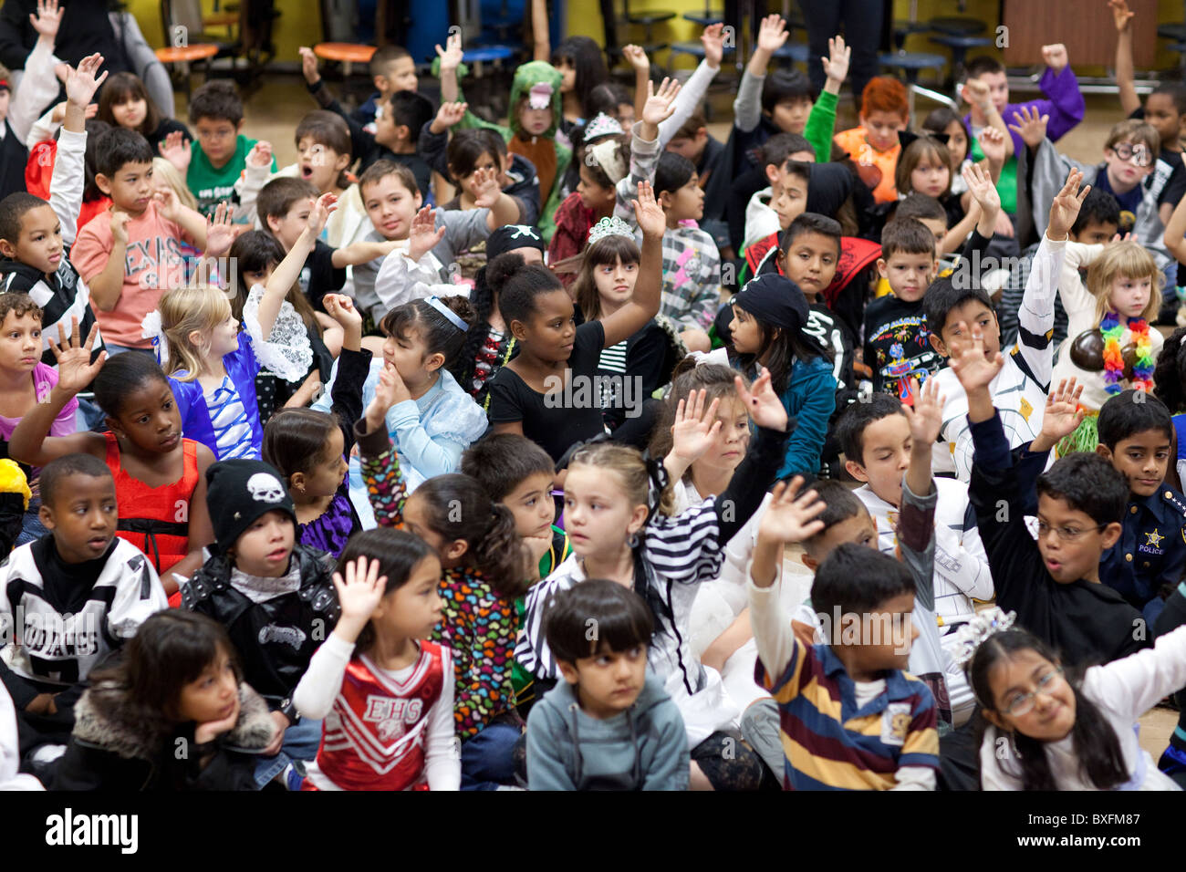 Grundschule 3. Klasse Schüler Raise Hände, eine Frage zu beantworten, wie sie Kinderbuchautorin Derrick Barnes hören sprechen Stockfoto