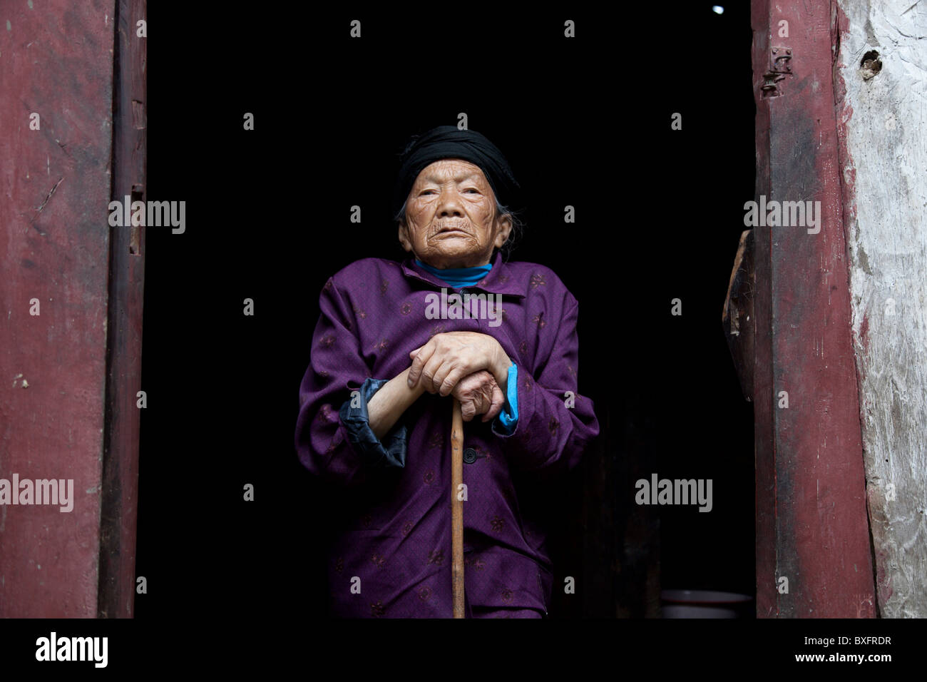 Ein Porträt einer alten Frau in einer abgelegenen Bergdorf in der Provinz Gansu in China. Stockfoto