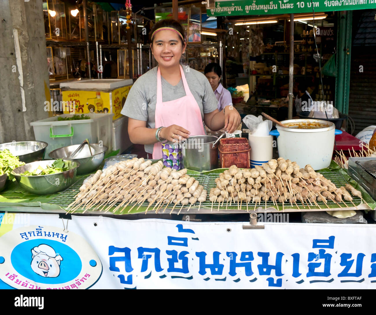 Frau verkauft Huhn am Spieß am Wochenendmarkt Chatuchak, Bangkok, Thailand. Stockfoto
