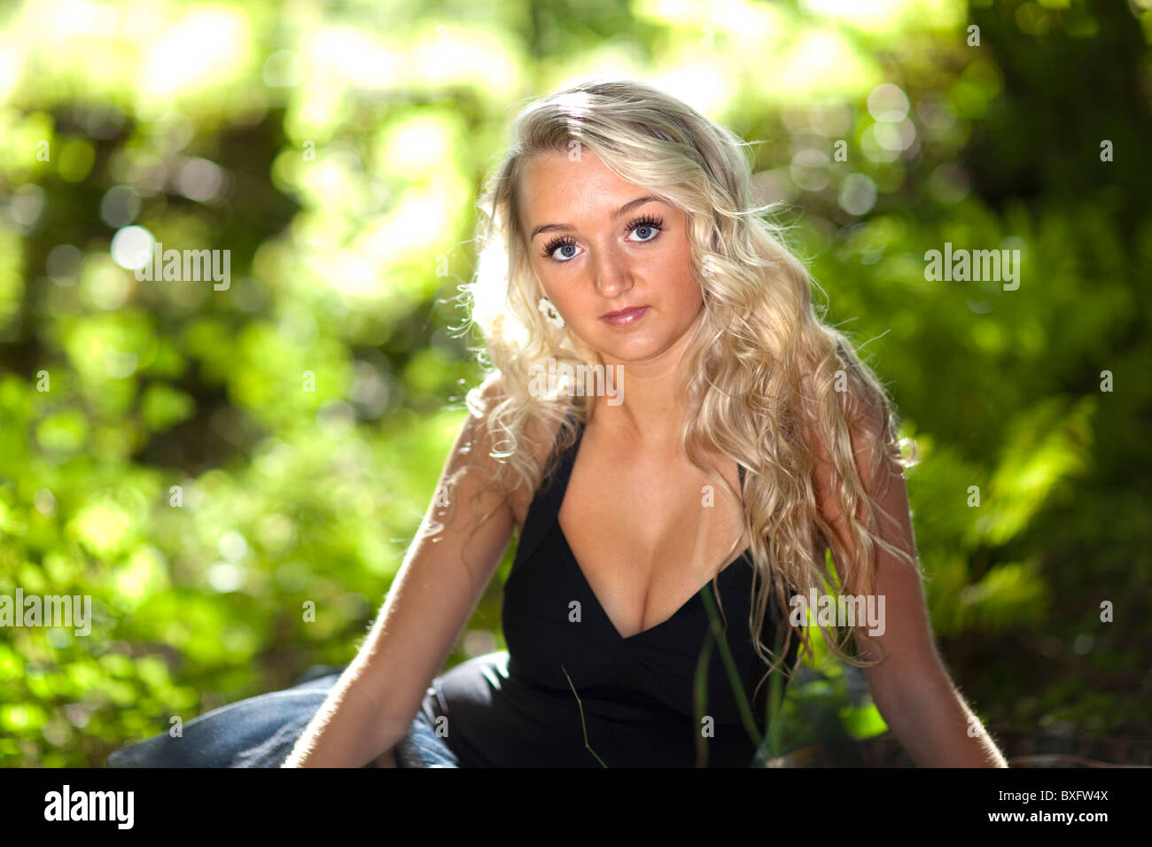 Schöne blonde Mädchen in einem grünen Garten Stockfoto